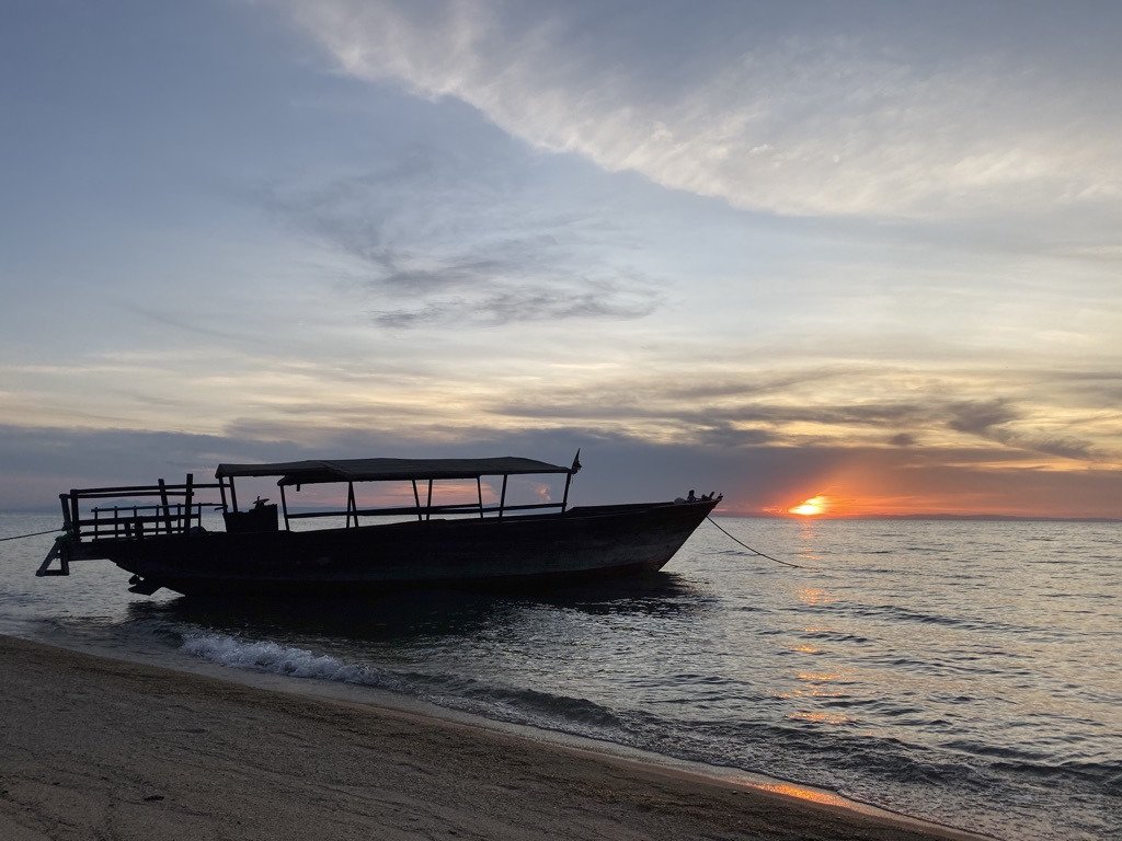 Canopied boat silhouetted against a Lake Tanganyika sunset