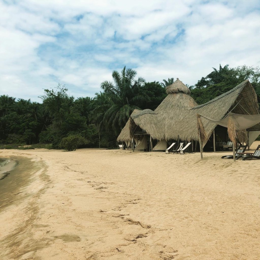 Empty sand beach with thatched bandas, Mahale Mountains National Park, Tanzania