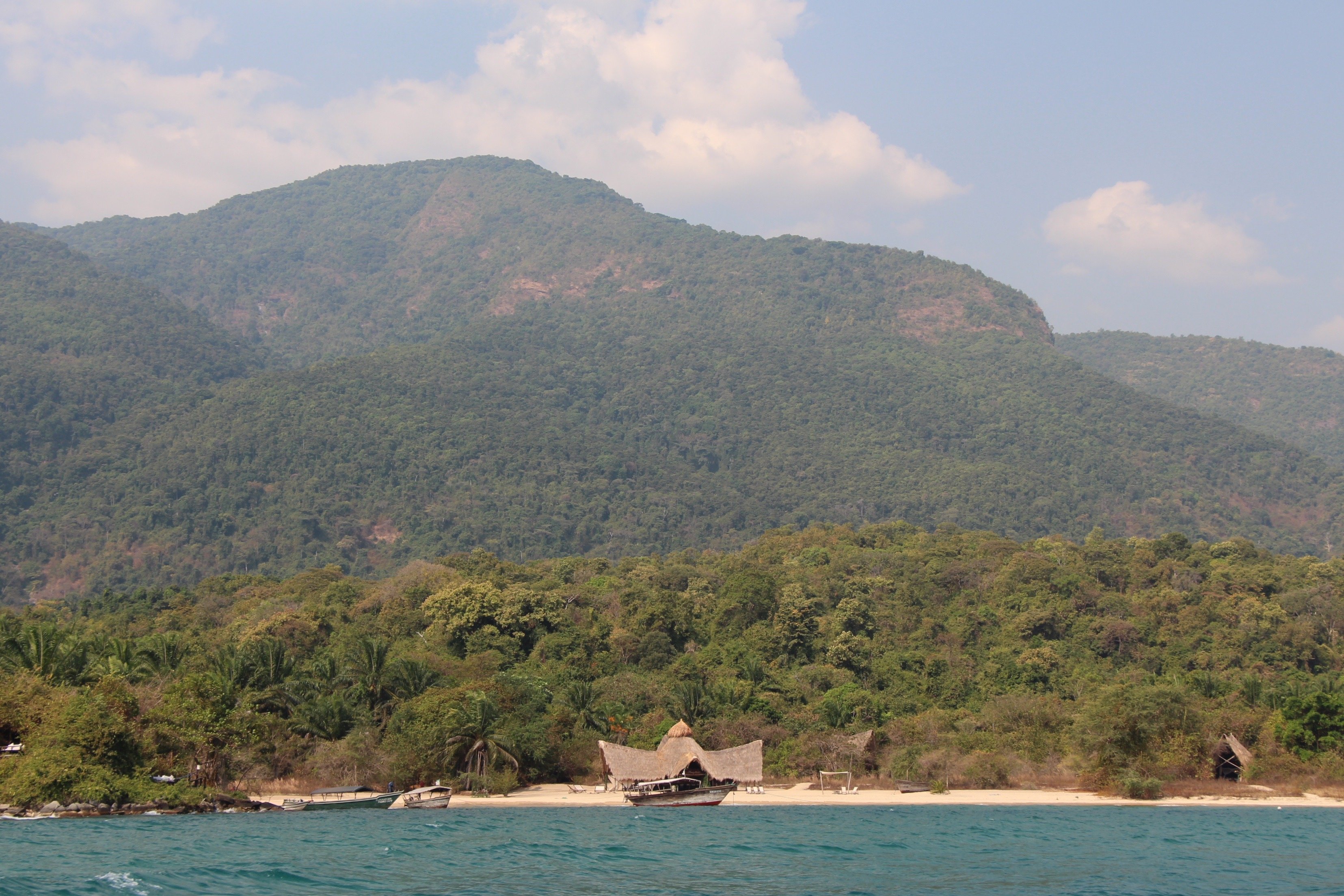 Forested Mahale mountains rising straight out of Lake Tanganyika above a tiny beach camp