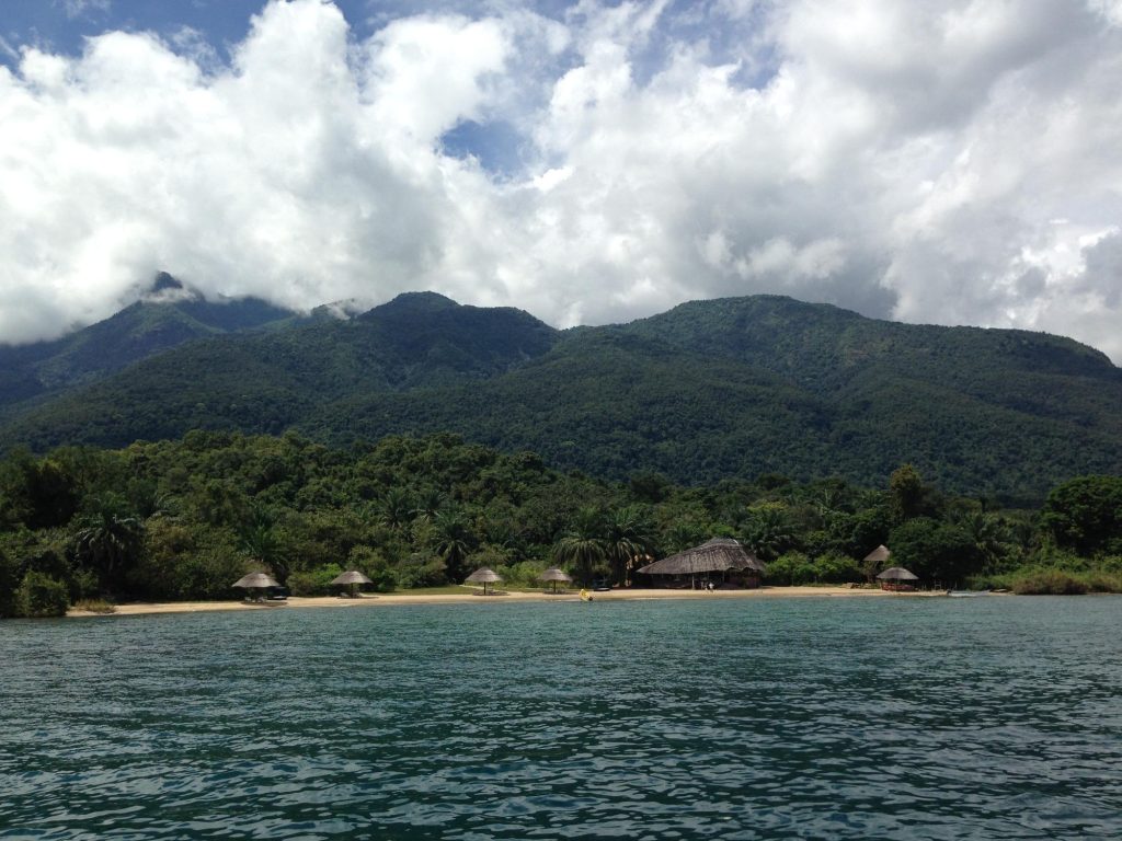 Forested peaks above thatched beach camp, Mahale Mountains National Park, Tanzania