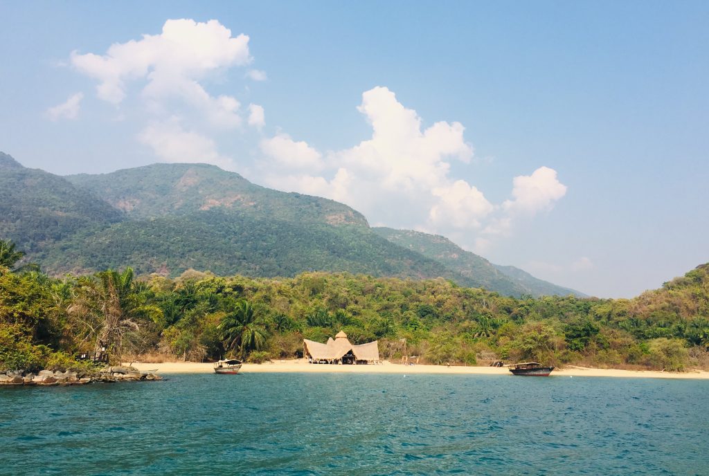 Two boats moored below forested mountain slopes, Mahale Mountains National Park, Tanzania