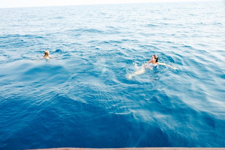 Two swimmers in deep blue lake water, Mahale Mountains National Park, Tanzania