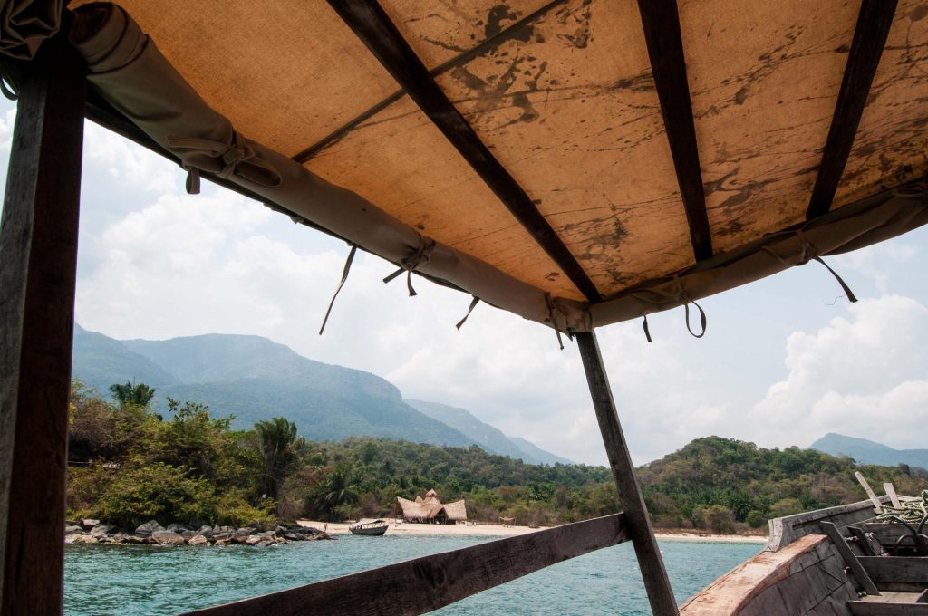 View from boat canopy toward thatched beach bandas, Mahale Mountains National Park, Tanzania